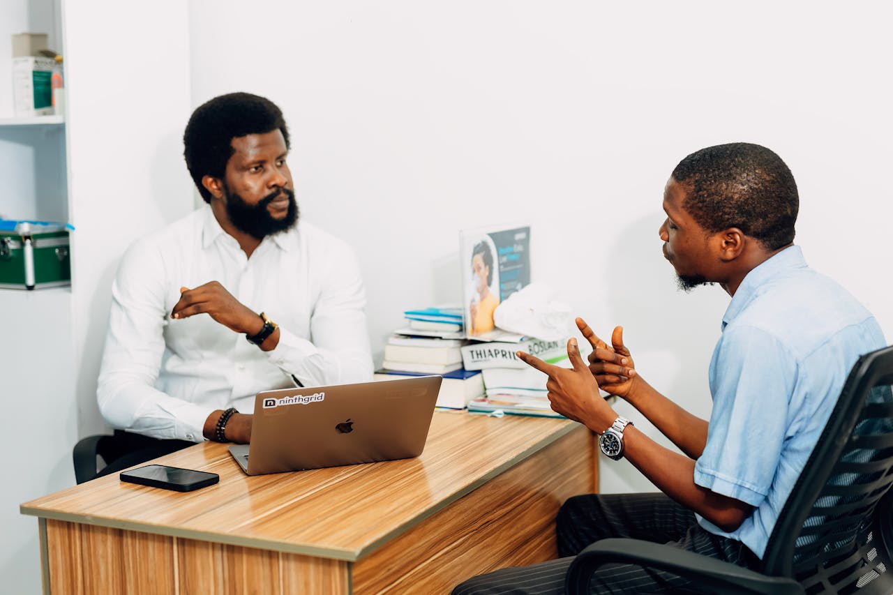 Services-01 Two adults engaged in a professional consultation in a Lagos office, discussing business or healthcare topics.